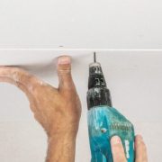 Workers are assembly gypsum wall. Plasterboard